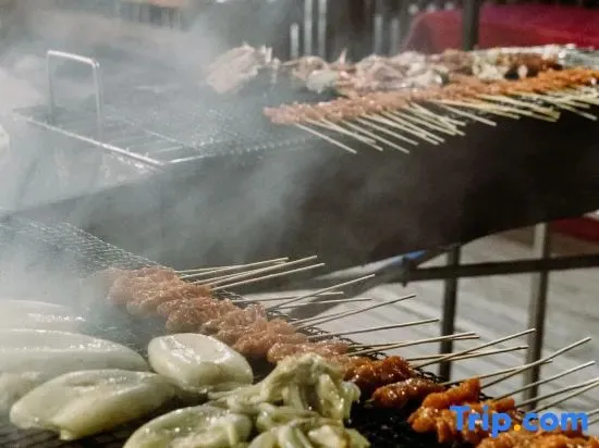 Brochettes de viande et de légumes grillent sur un barbecue.