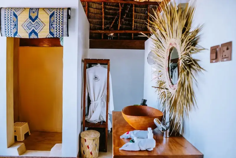 Une salle de bain lumineuse avec une douche ouverte et un lavabo en bois.