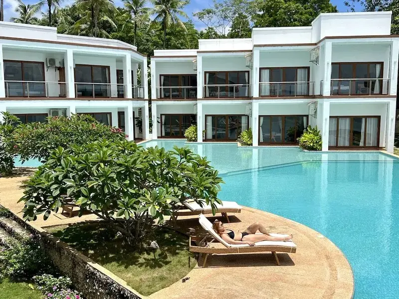 Une piscine turquoise bordée de transats invite à la détente.
