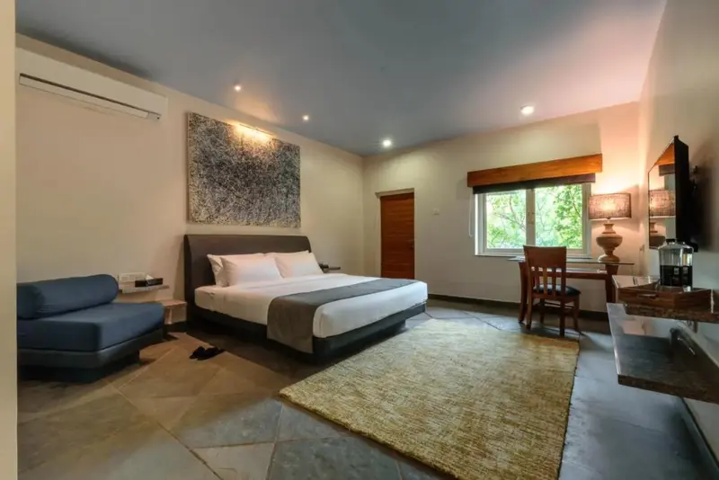 Une chambre lumineuse avec un grand lit et un coin salon.