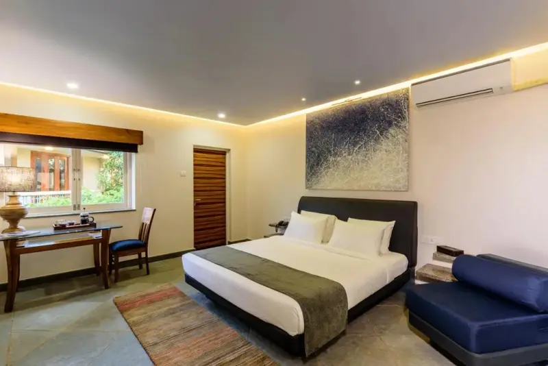 Une chambre lumineuse avec un grand lit et un coin bureau.
