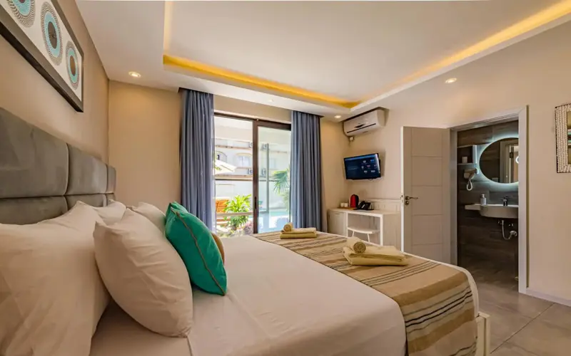 Une chambre lumineuse avec un grand lit et un accès à une terrasse.