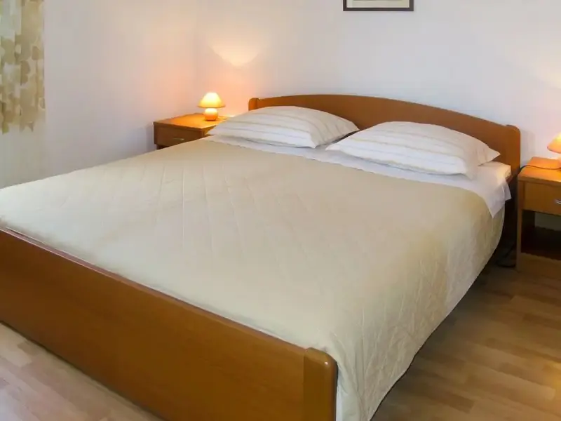 Une chambre lumineuse avec un grand lit recouvert d'une courtepointe.