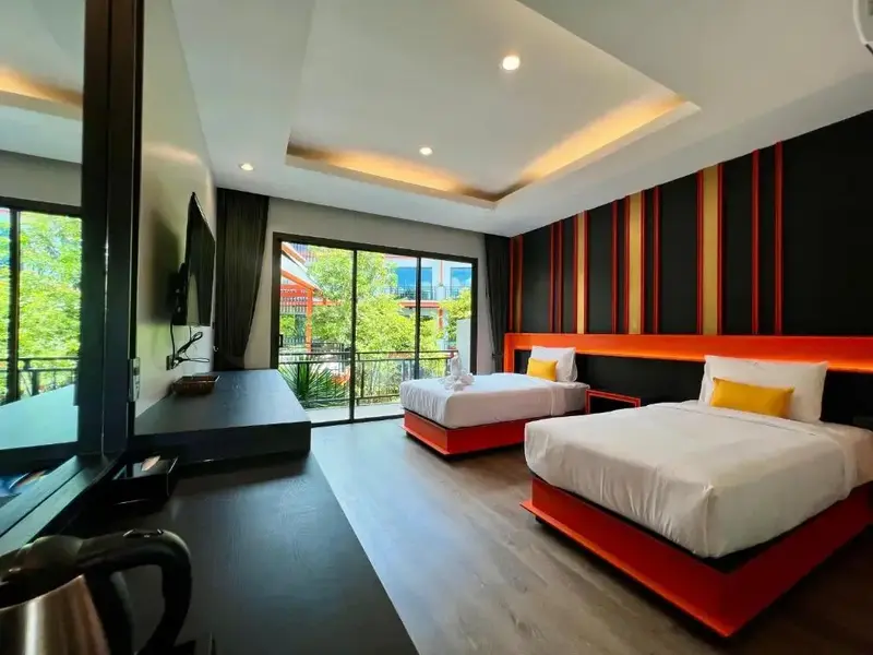 Chambre moderne avec deux lits simples et une grande baie vitrée.