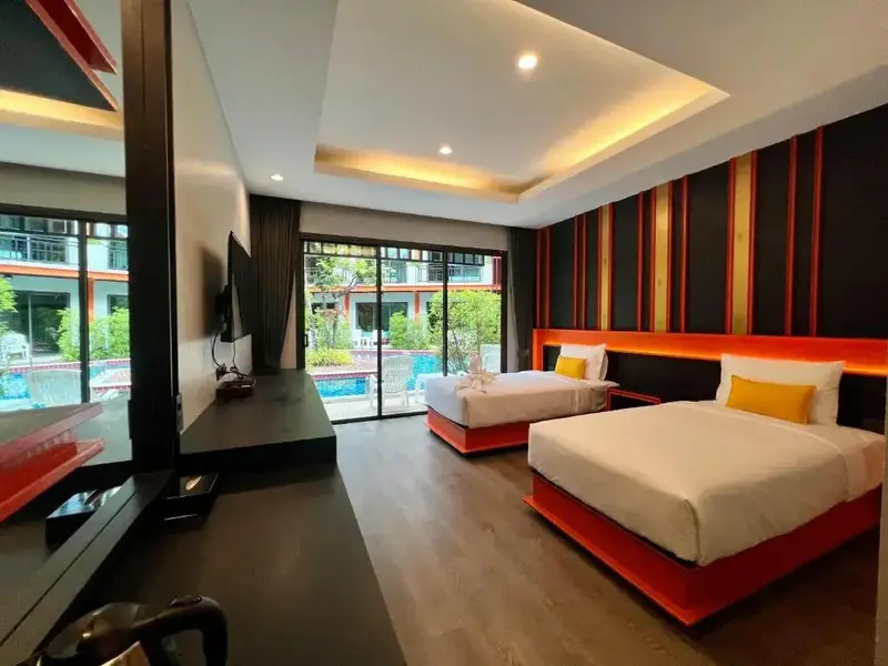 Une chambre lumineuse avec deux lits simples et vue sur la piscine.