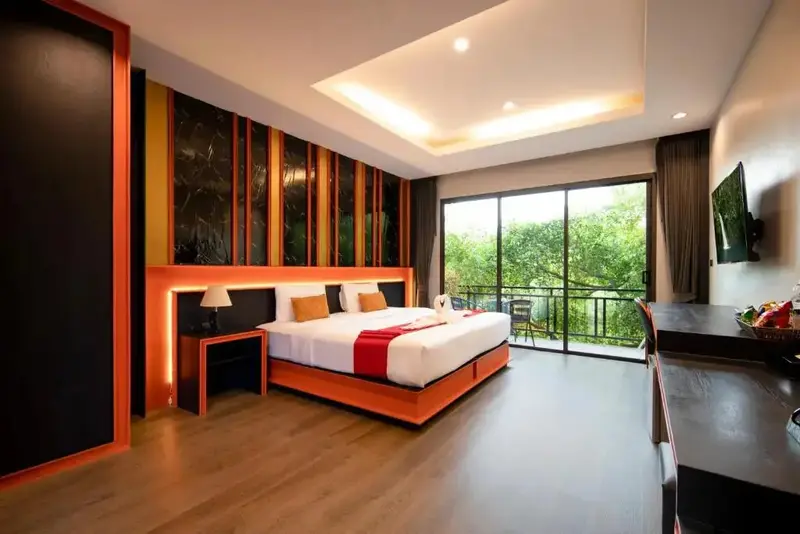 Une chambre lumineuse avec un grand lit et une vue sur la végétation.