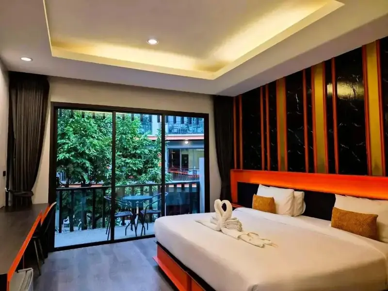 Une chambre lumineuse avec un grand lit et un accès à un balcon.