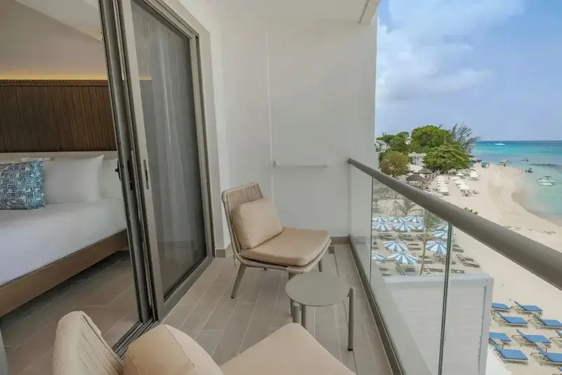 Une terrasse aménagée offre une vue sur la plage et la mer turquoise.