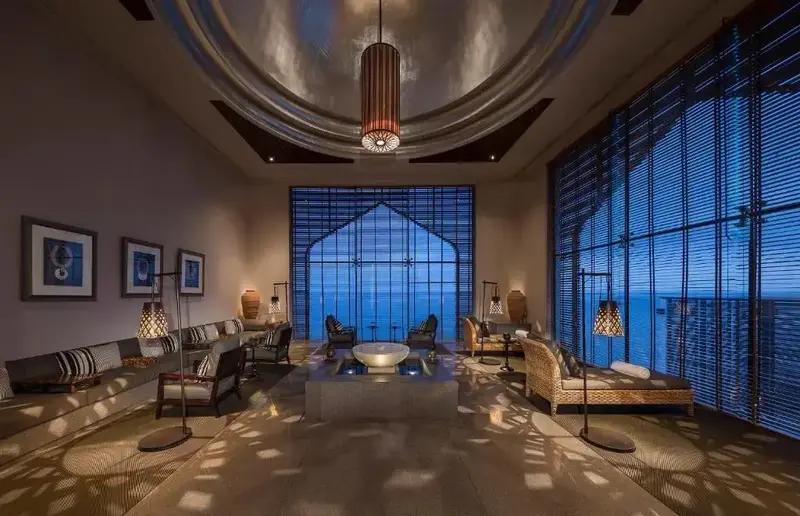Un espace de détente intérieur avec des canapés et une vue sur la mer par de grandes baies vitrées.