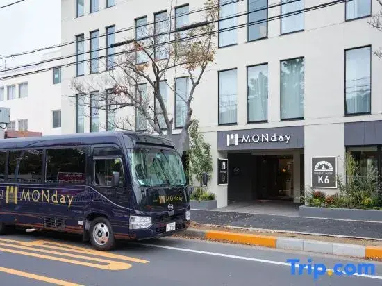 Façade d'un bâtiment moderne avec un minibus garé devant.