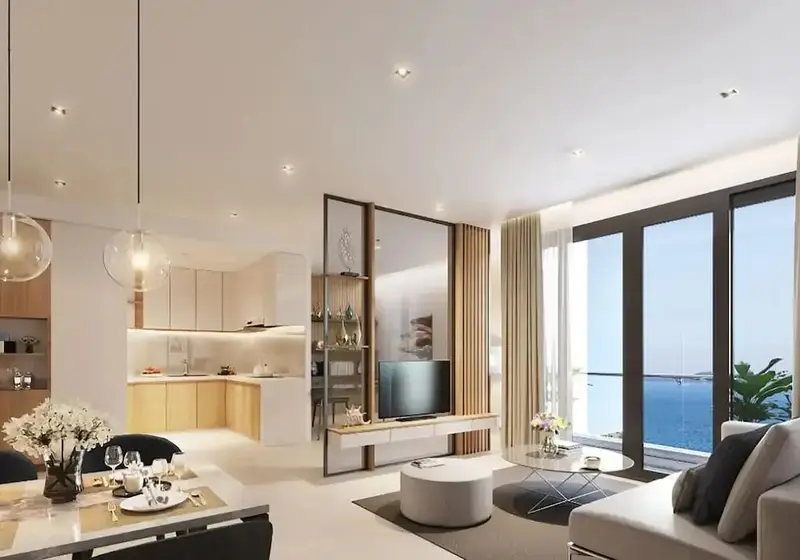 Interieur lumineux avec espace cuisine, salle a manger et coin salon donnant sur une vue mer.