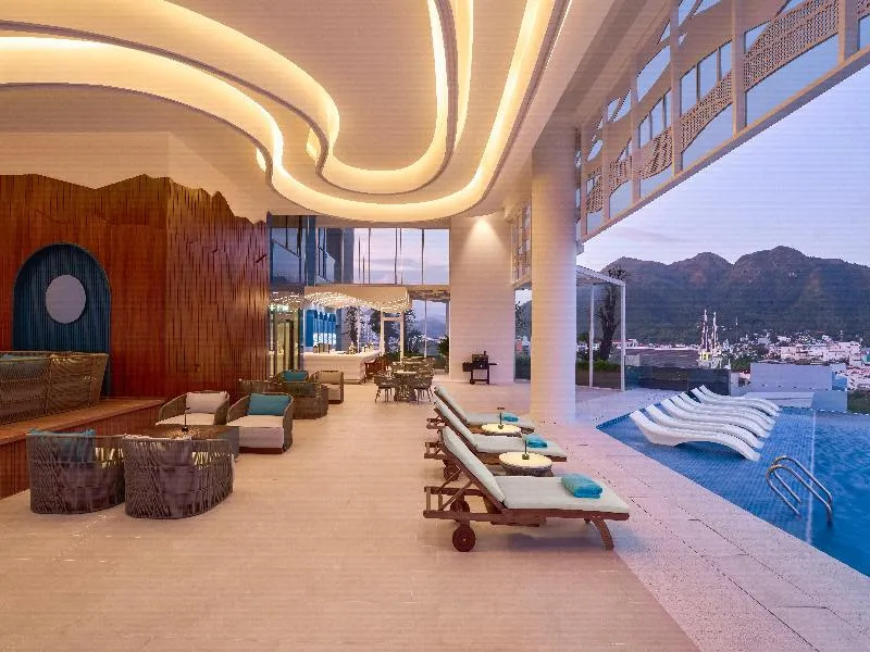 Espace de détente lumineux avec transats au bord d'une piscine à débordement.