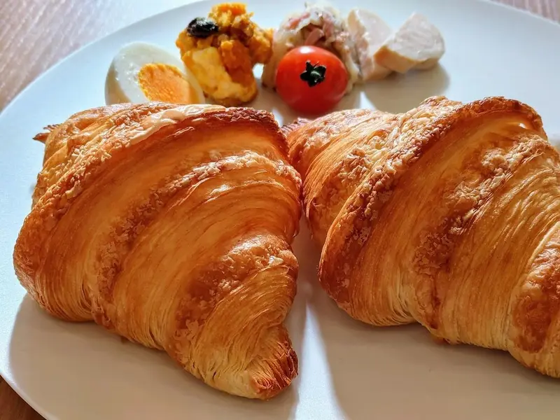 Assiette de croissants et d'accompagnements pour le petit-déjeuner.