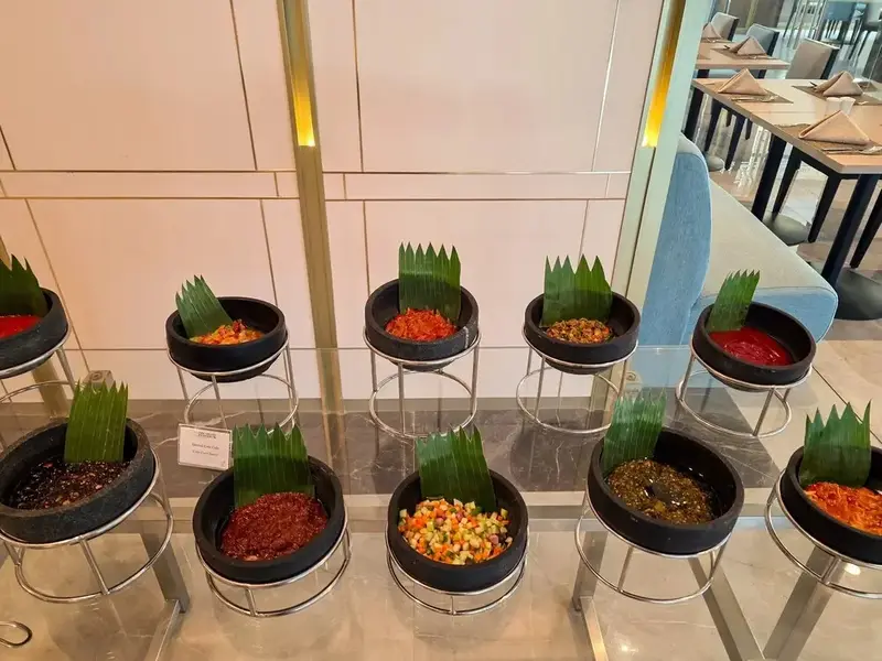 Présentation de condiments variés dans des récipients décoratifs.