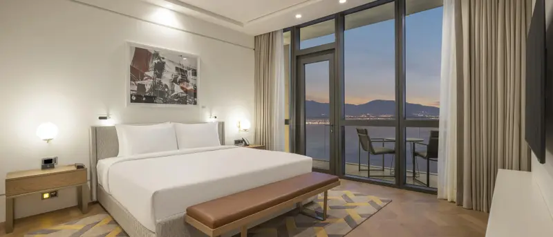 Une chambre lumineuse avec un grand lit et une vue sur la mer.