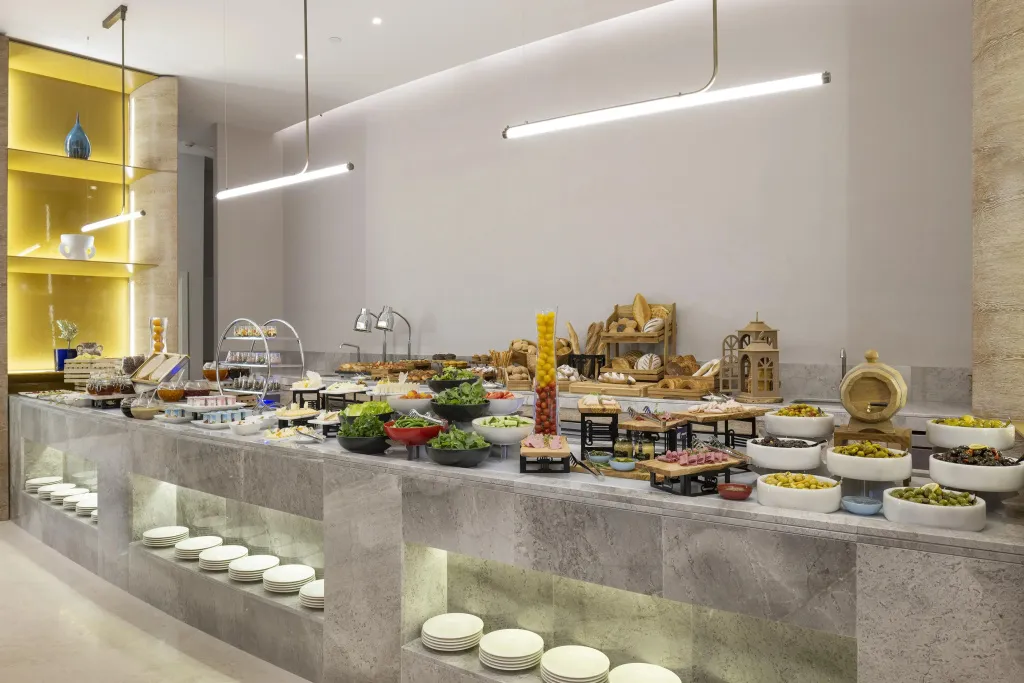 Un buffet garni de plats variés est présenté sur un long comptoir.