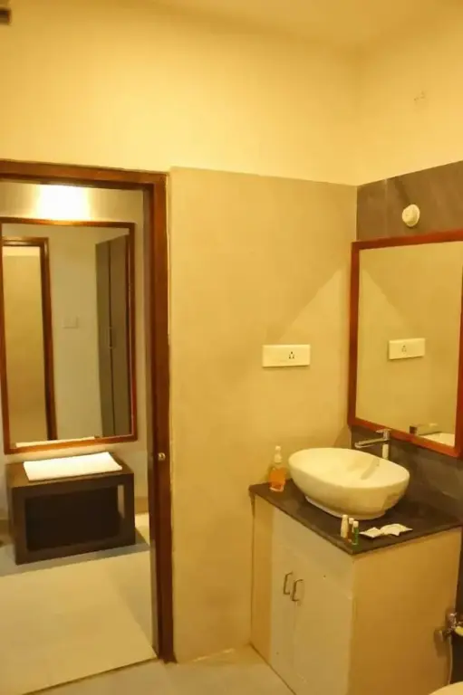 Une salle de bain lumineuse avec deux vasques et des miroirs.