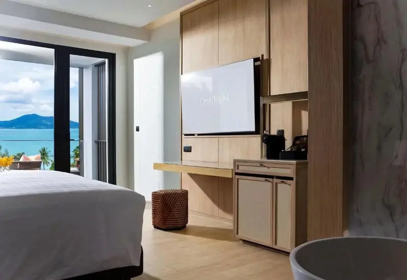 Une chambre lumineuse avec un grand lit et une vue sur la mer.