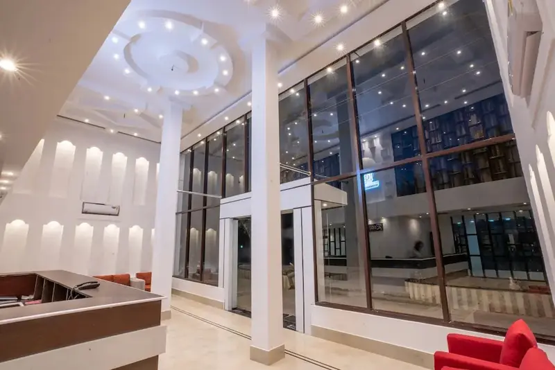 Hall d'accueil lumineux avec comptoir et larges baies vitrées.