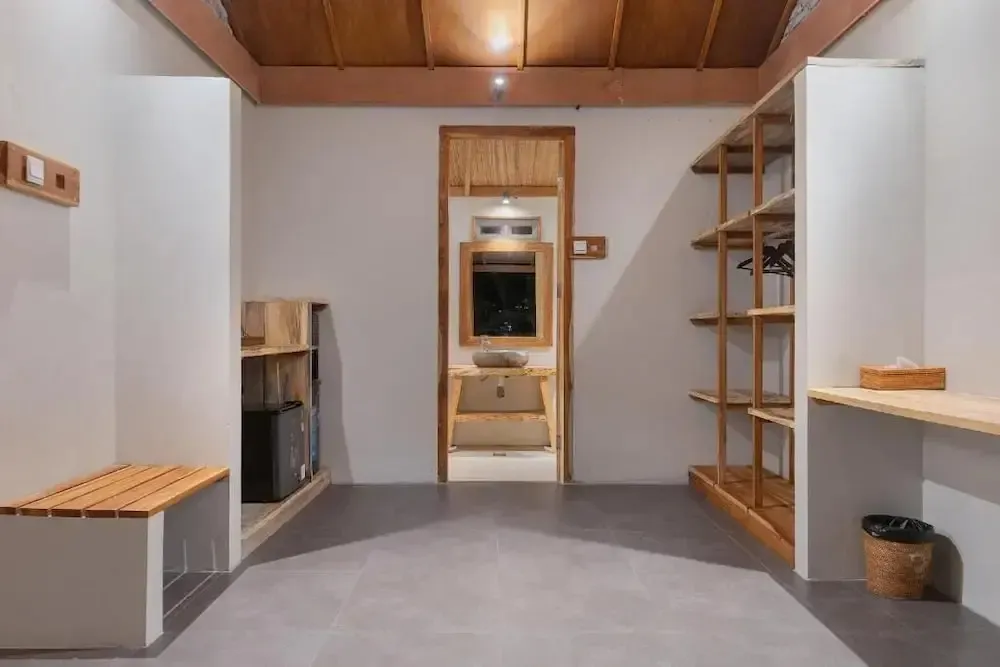 Espace intérieur clair avec des étagères en bois et un banc.