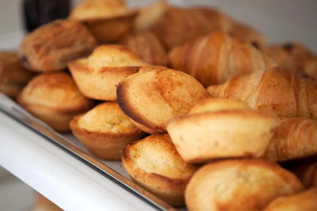 Présentation de viennoiseries dorées sur un présentoir.