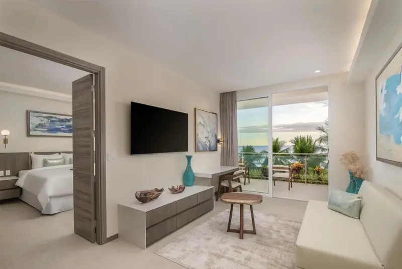 Espace de vie lumineux avec accès à un balcon offrant une vue sur la mer.