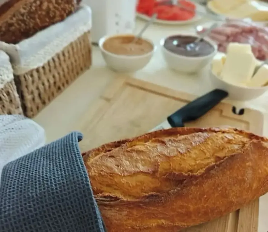 Une table lumineuse présente des pains, des tartinades et des charcuteries.