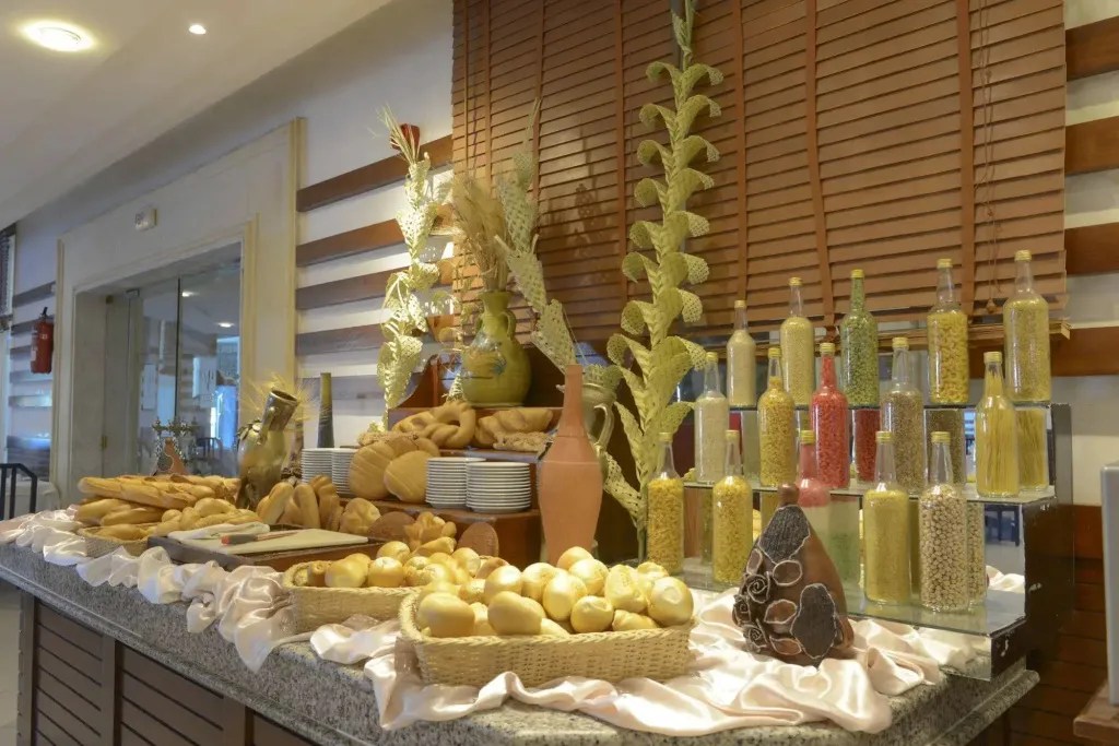 Un buffet propose une variété de pains et de céréales dans un espace lumineux.