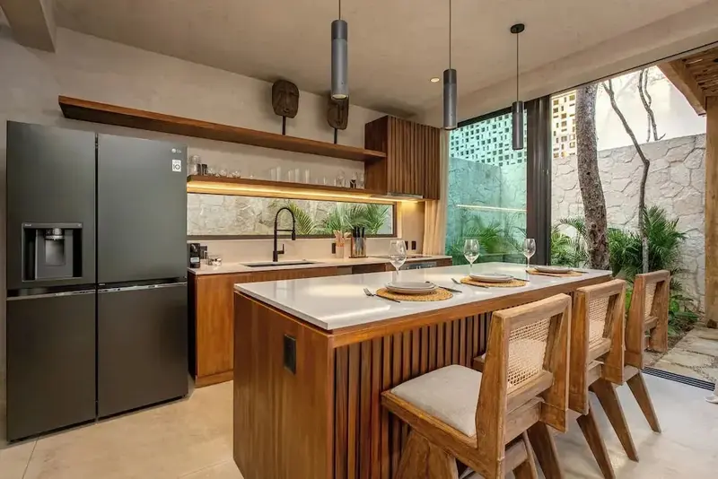 Une cuisine moderne avec un îlot central et des tabourets en bois.