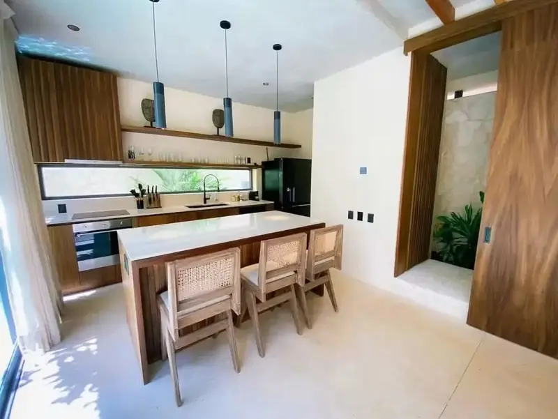 Une cuisine moderne avec un îlot central et des tabourets.