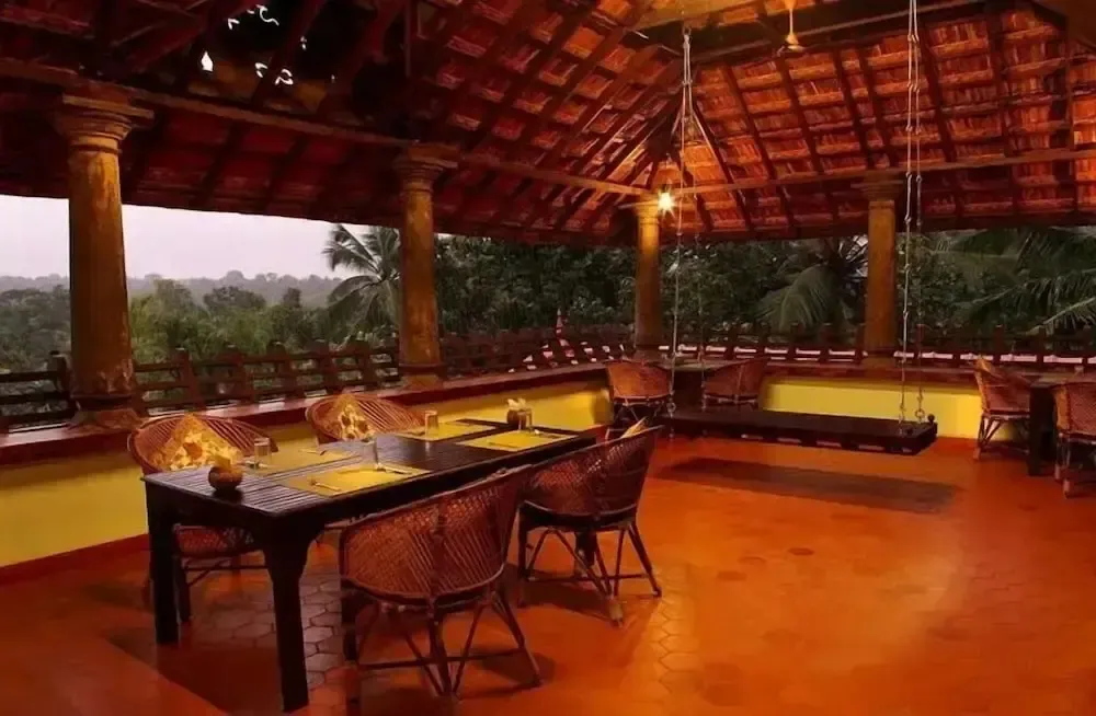 Une terrasse abritée avec des tables et des chaises en bois.