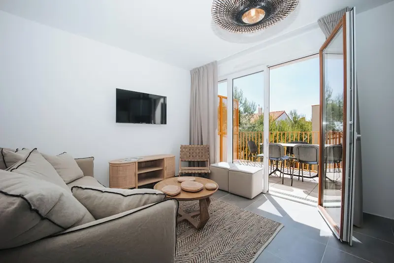 Un salon lumineux s'ouvre sur une terrasse avec mobilier de jardin.