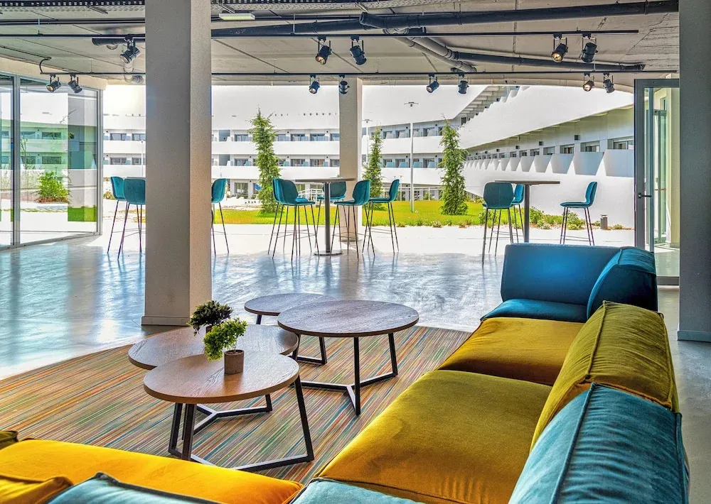 Espace de détente intérieur avec canapés colorés et tables basses.