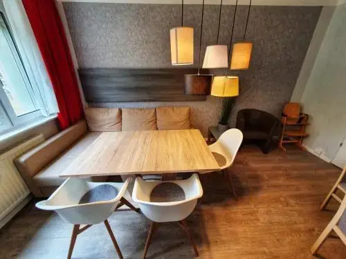Une table à manger en bois est entourée de chaises dans une pièce lumineuse.