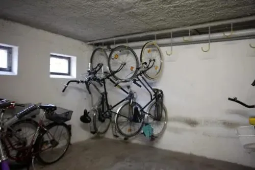 Plusieurs bicyclettes sont suspendues au mur dans une pièce claire.