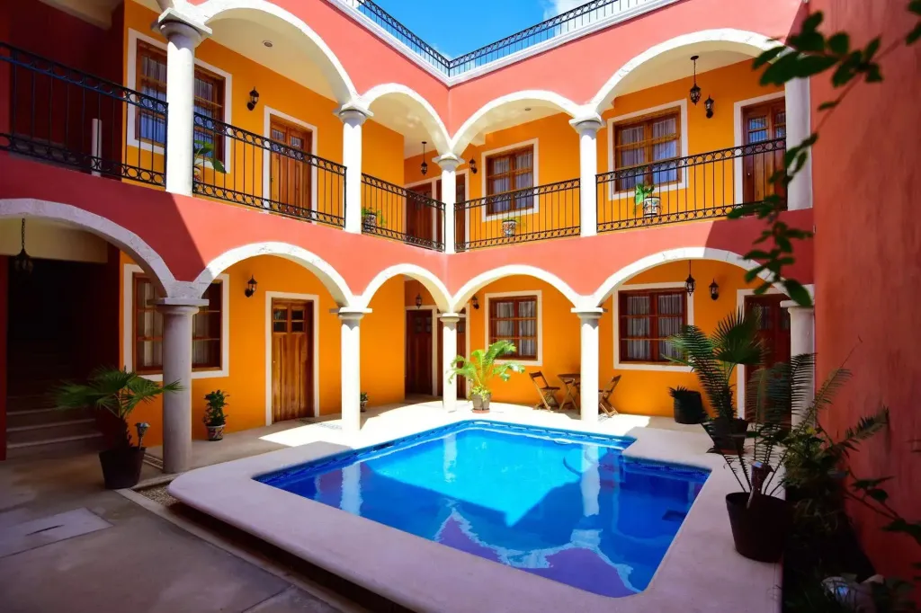 Cour intérieure colorée avec une piscine et des balcons fleuris.