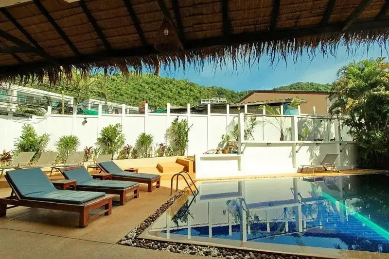 Transats bleus alignés au bord d'une piscine rectangulaire.