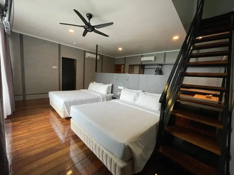 Une chambre lumineuse avec deux lits et un escalier en bois.