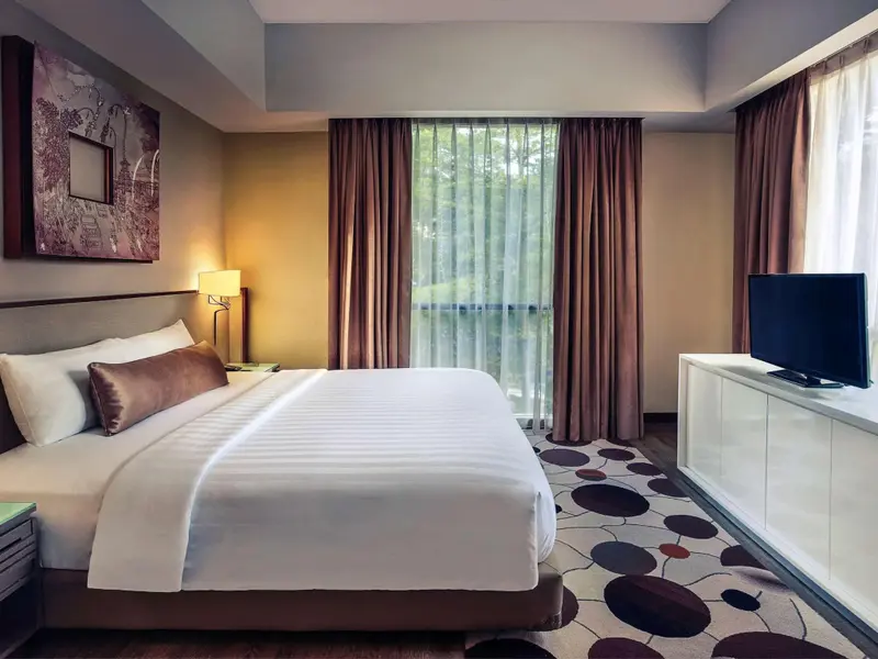 Une chambre lumineuse avec un grand lit recouvert d'une courtepointe blanche.