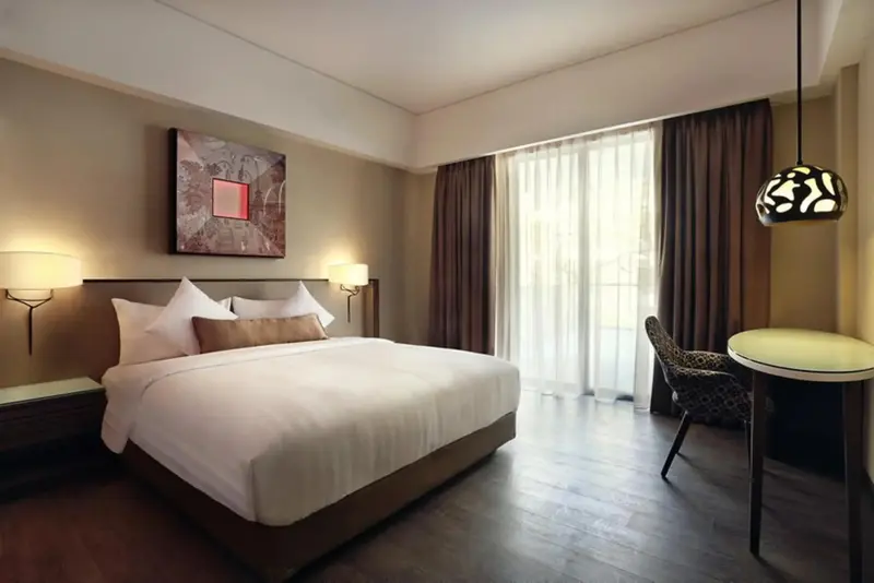 Une chambre lumineuse avec un grand lit et un coin salon.