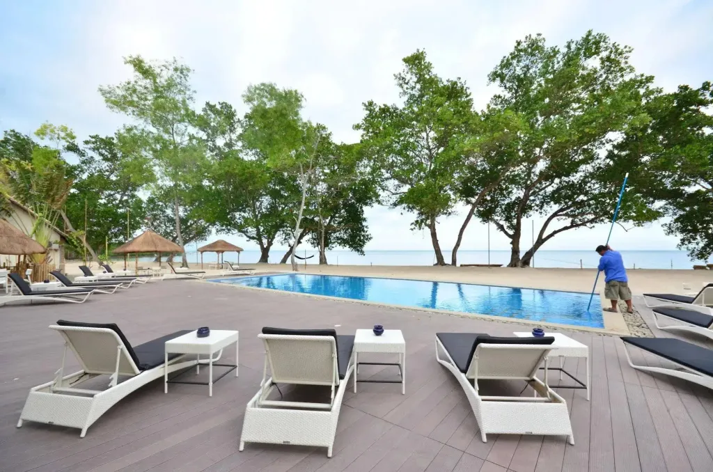 Terrasse avec transats et piscine au bord de la mer.
