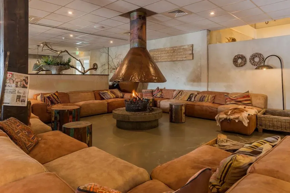 Un grand espace de détente intérieur avec un foyer central et de nombreux canapés.