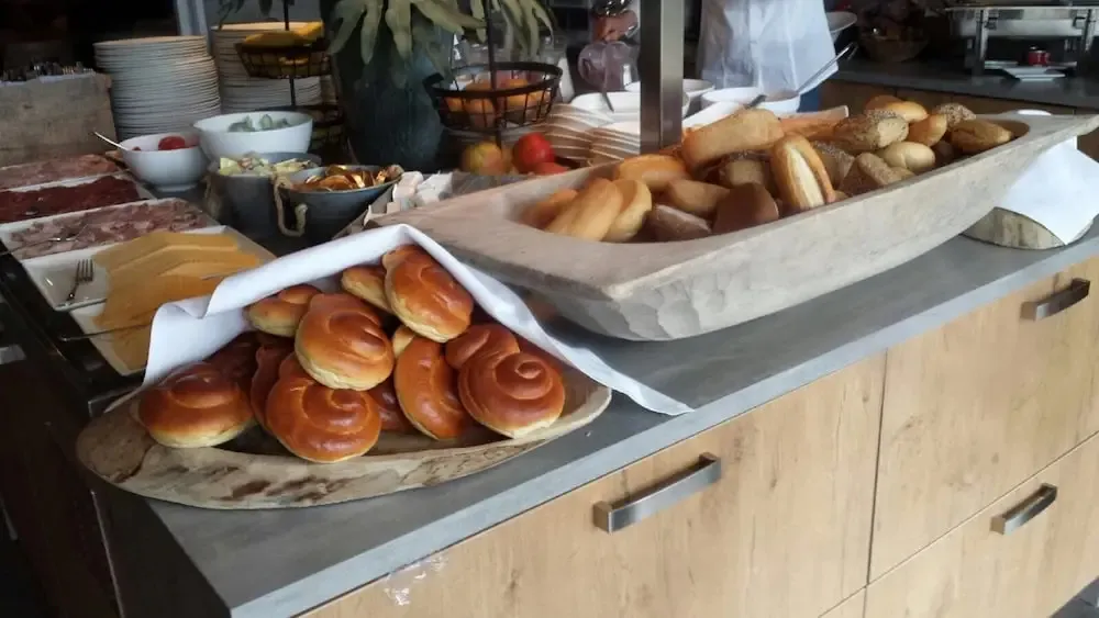 Présentation de viennoiseries et de pains variés sur un buffet.