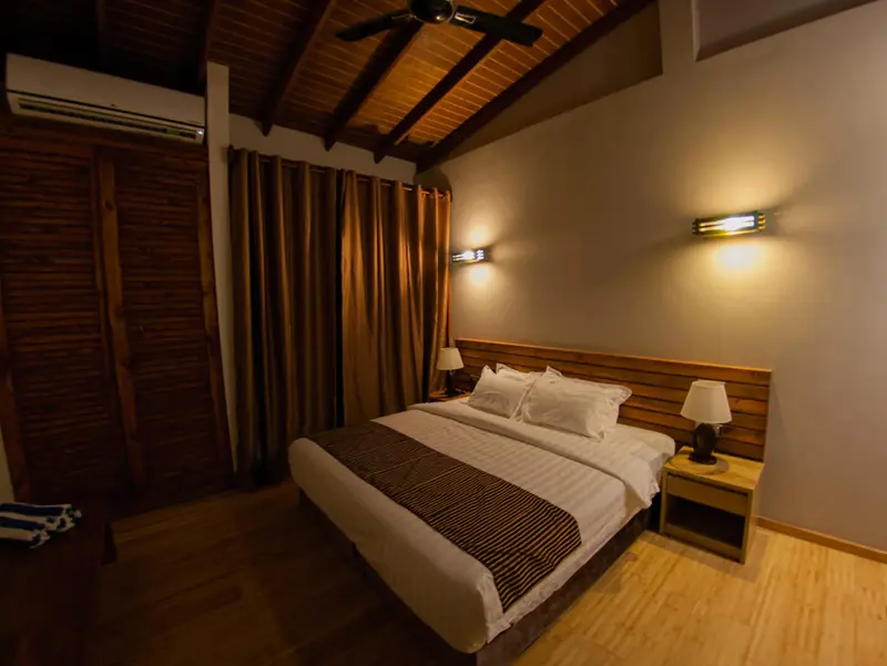 Une chambre lumineuse avec un grand lit et des rideaux bruns.