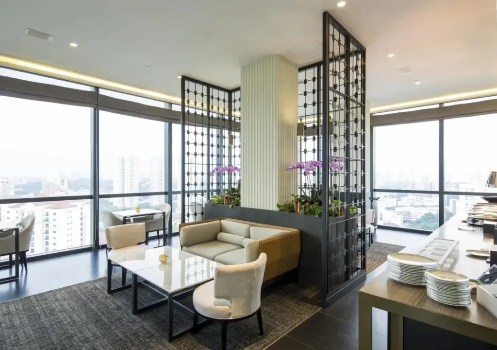 Espace de détente lumineux avec canapés et vue sur la ville.