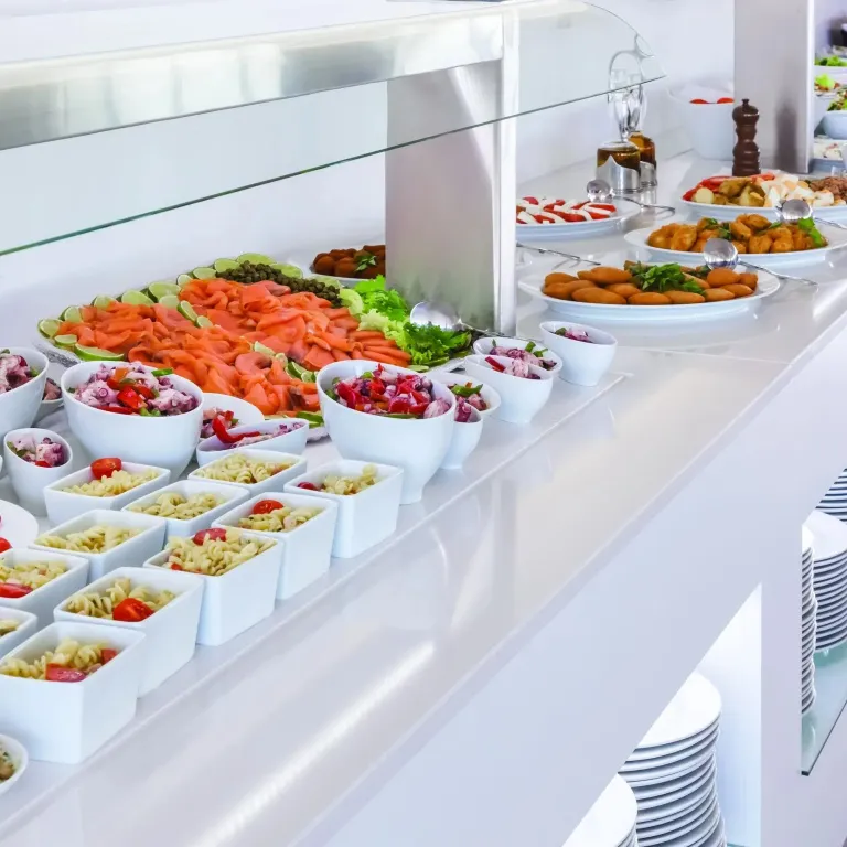 Un buffet propose une variété de salades, de crudités et de plats préparés.