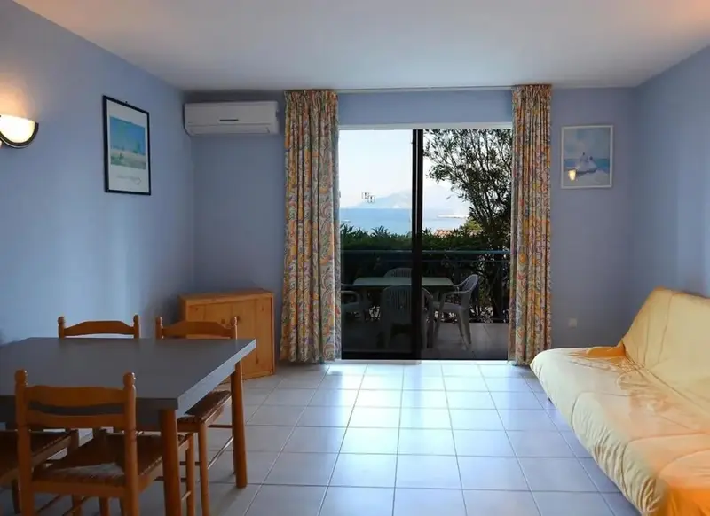 Une piece de sejour lumineuse avec un espace repas et un acces sur une terrasse.