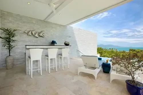Terrasse aménagée avec bar et vue sur la mer.