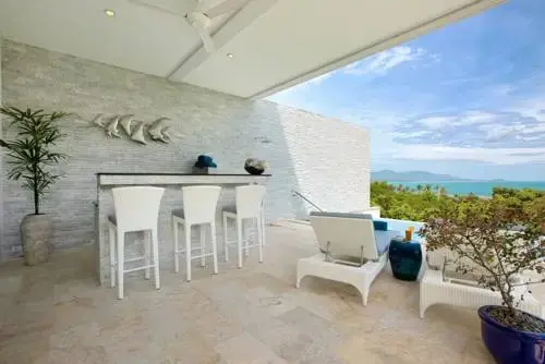 Terrasse aménagée avec bar et vue sur la mer.