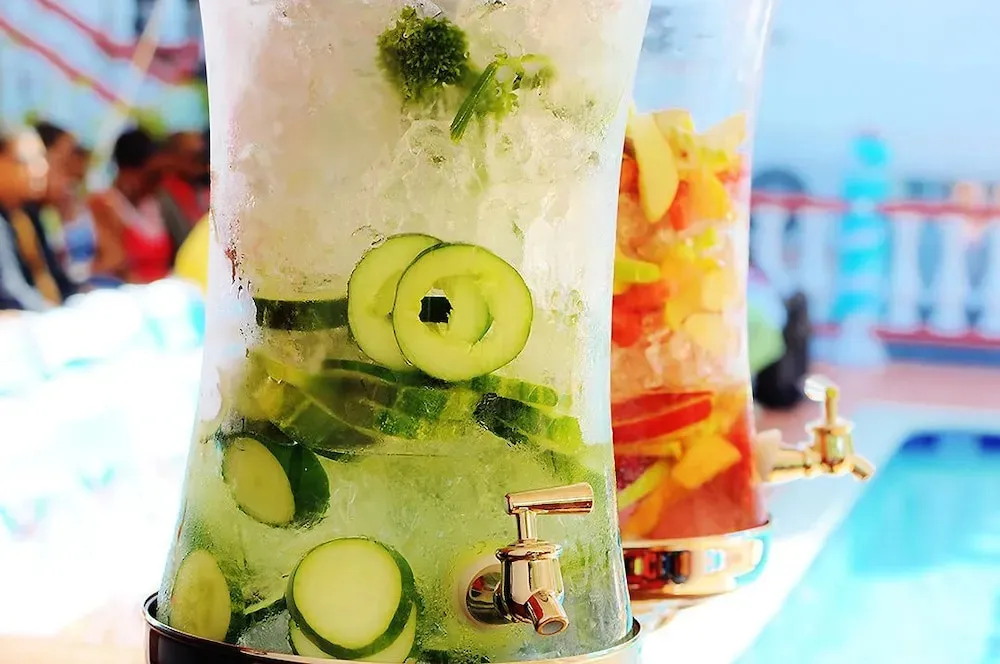 Deux distributeurs de boissons rafraîchissantes à l'eau et aux fruits sont présentés au premier plan.